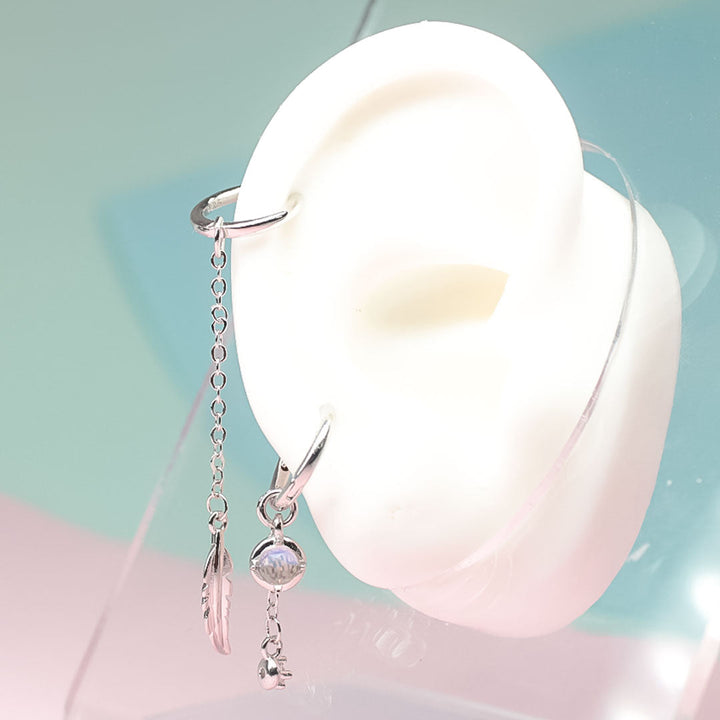 Exklusive, asymmetrische Damen Federohrringe aus 925er Sterlingsilber, verziert mit blauem Mondstein.