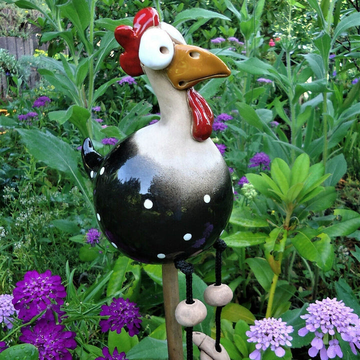 Freches Huhn als Gartenfigur, klettert auf Zaun. Wetterfeste Dekoration für Garten, Terrasse & Balkon.
