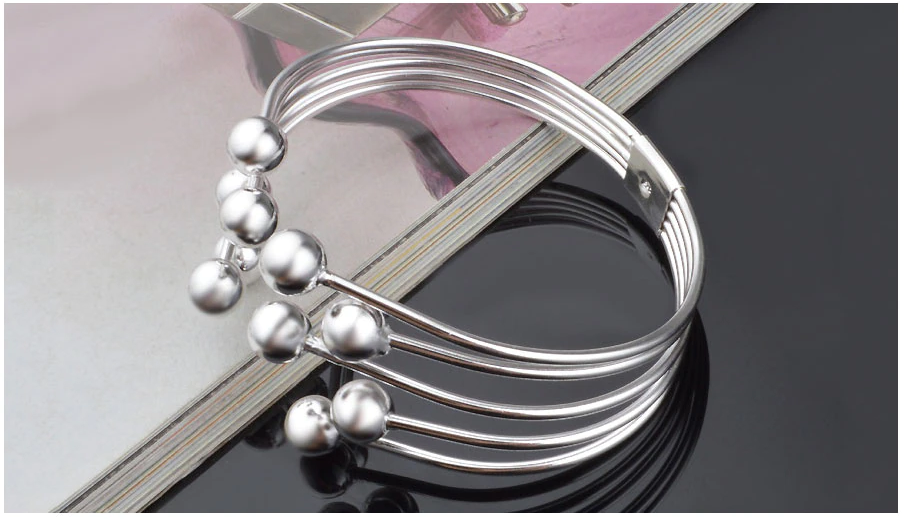 Damen Silberarmband mit glänzenden Perlen, offenes Design. Verstellbares Schmuckstück und schönes Accessoire.