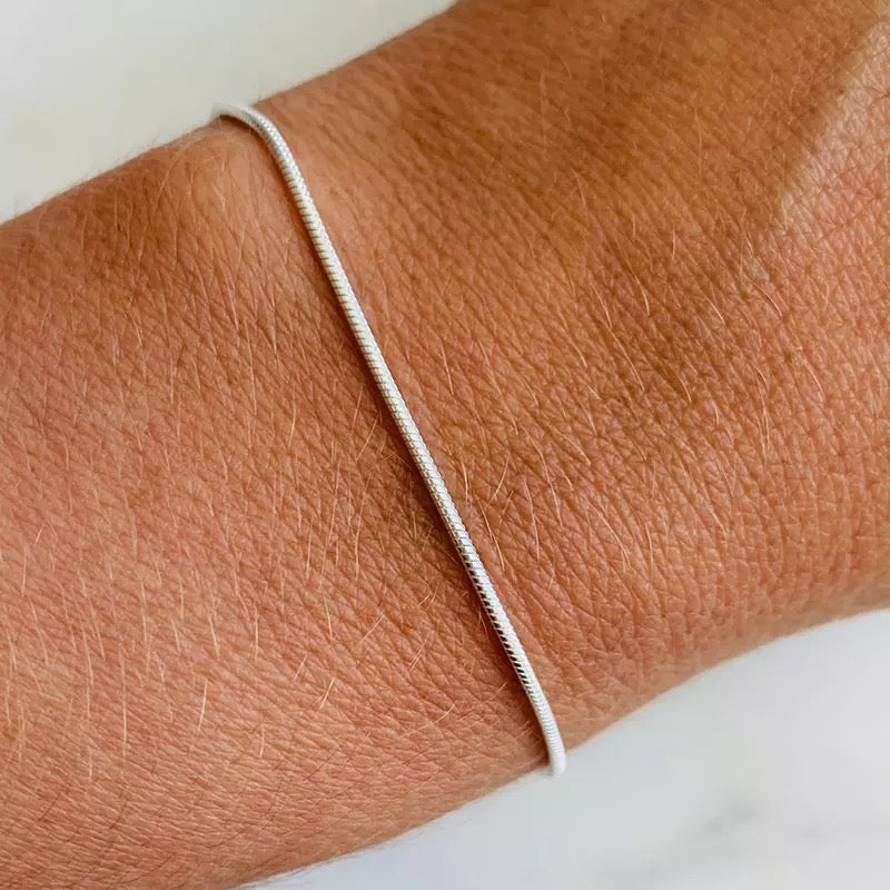 Elegantes minimalistisches Silberarmband für Damen und Herren mit auffälliger Schlangenschließe als Blickfang.