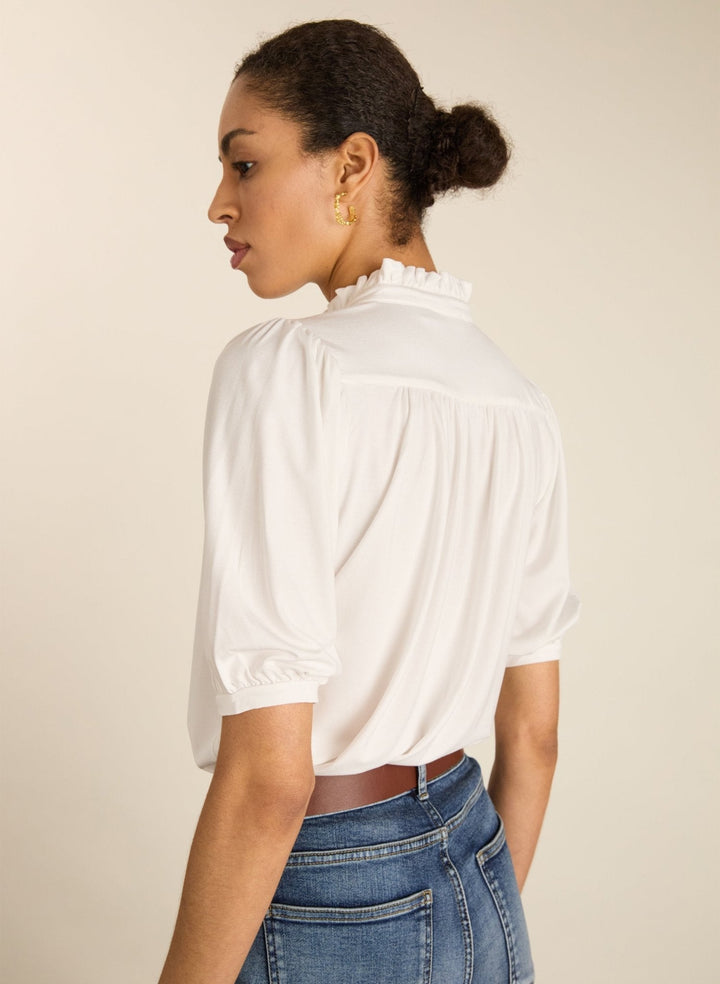 Feminine Kurzarm-Damenbluse mit Rüschenkragen in Weiß. Eine vielseitige Option für warme Tage.