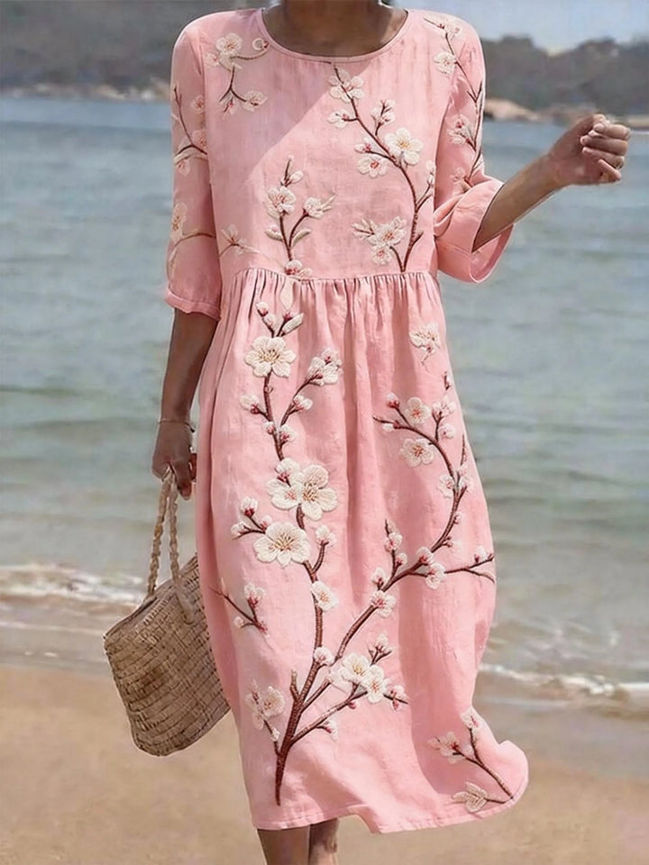 Lässiges Damen Midikleid in Rosa mit Blumenmuster und eleganten Ellenbogenärmeln. Perfektes Sommerkleid für feminine Outfits.