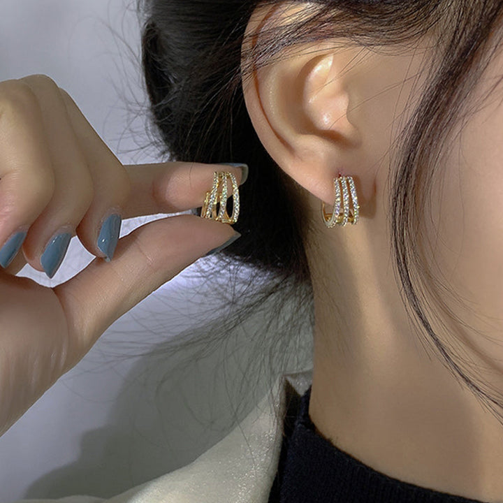 Glänzende Goldohrstecker für Damen, verziert mit Zirkonia-Kristallen, ideal als Geschenkidee.