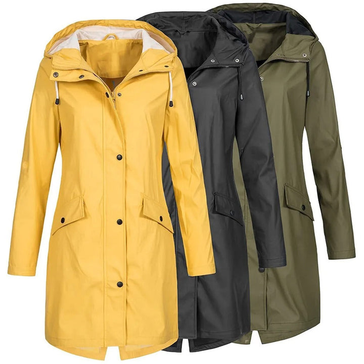 Dame trägt langen, wasserdichten Regenmantel beim Spaziergang. Modische, ganzjährige Outdoor-Jacke für Frauen.