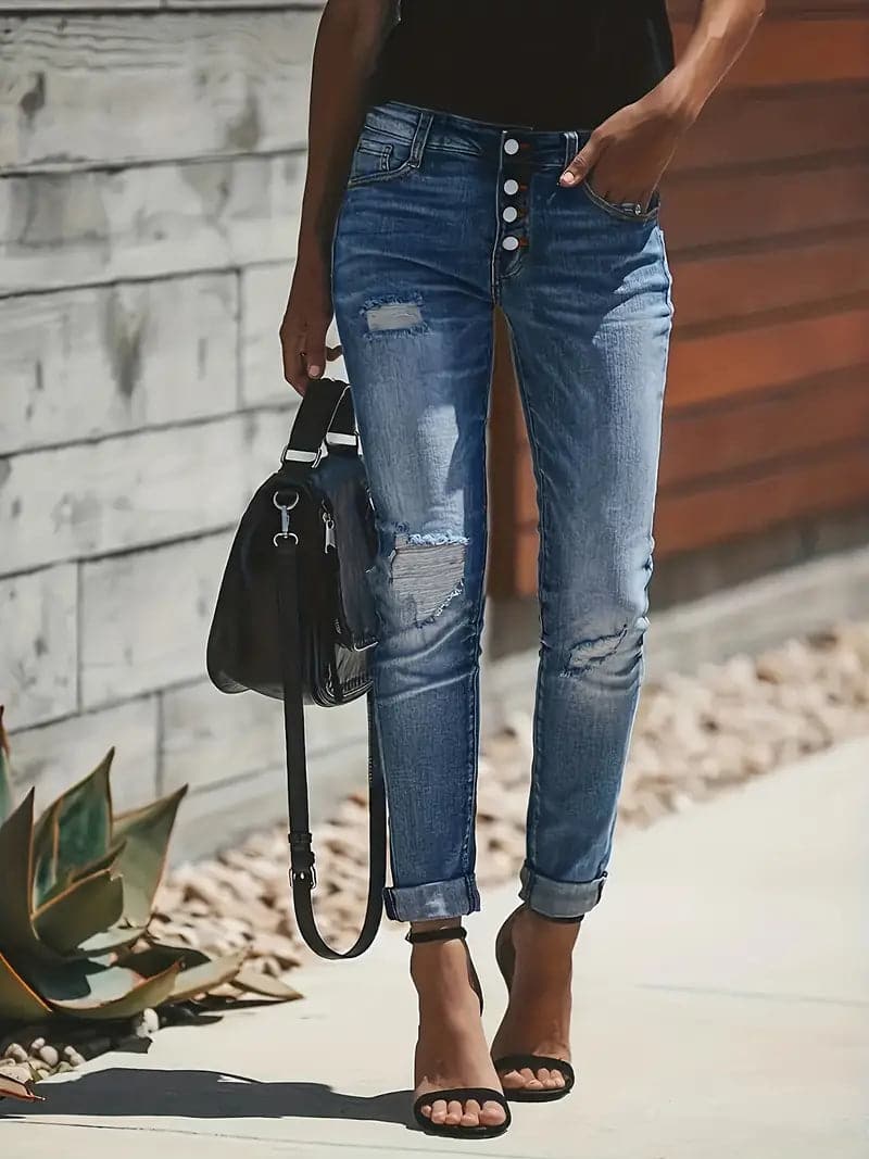 Stylische Damen Stretchjeans in Mittelblau mit Zerrdetails. Perfekt für trendige Alltags- und Freizeitlooks im Frühling/Herbst.