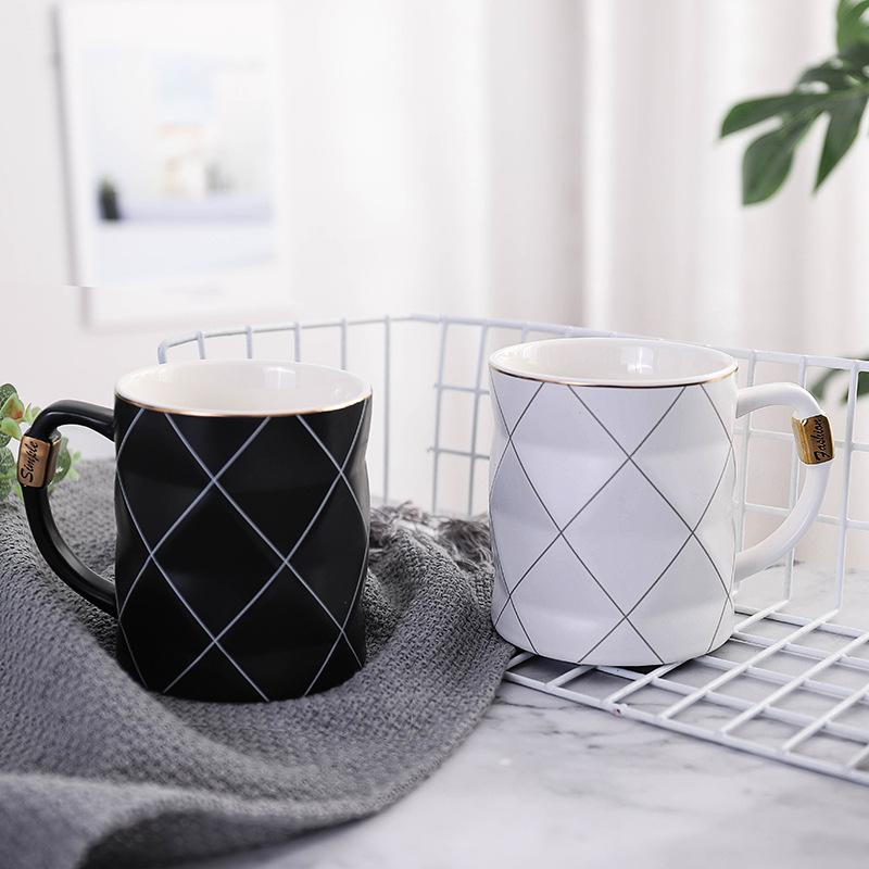 Schwarz-weiße geometrische Keramiktasse. Moderner Becher für Kaffee, Tee oder als stilvolles Küchenaccessoire.