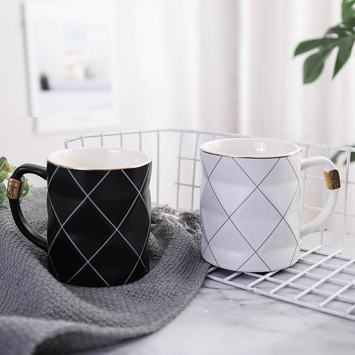 Schwarz-weiße geometrische Keramiktasse. Moderner Becher für Kaffee, Tee oder als stilvolles Küchenaccessoire.