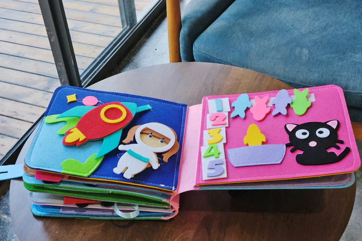 Nahaufnahme des Montessori Filz Abenteuerbuchs, zeigt detaillierte interaktive Elemente für Kleinkinder.