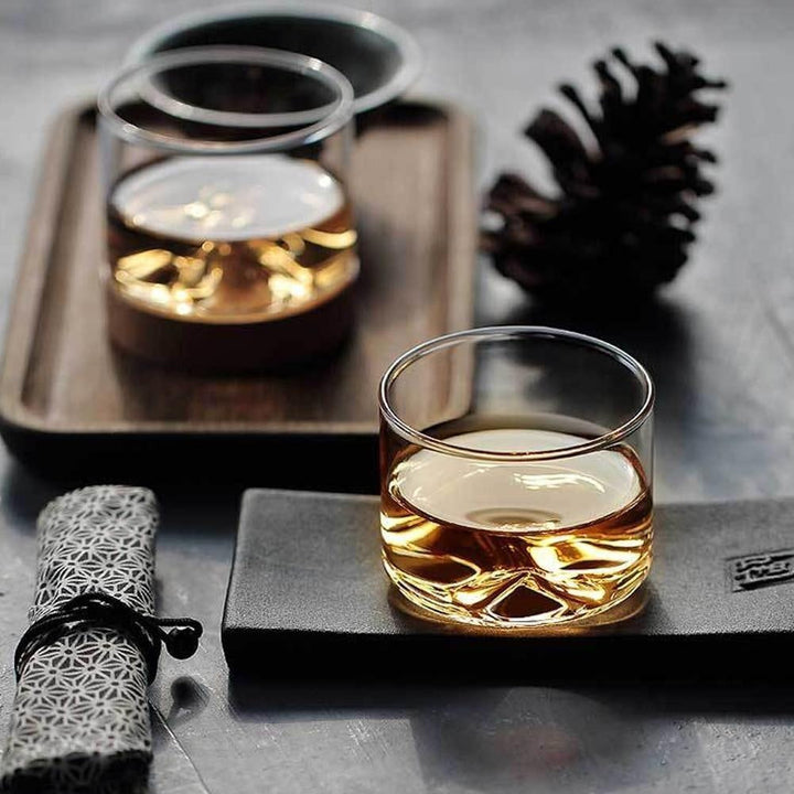 Modernes Mt. Hotaka Trinkglas: Berggipfel aus Borosilikatglas mit rustikaler Holzbasis, ideal für Whisky.