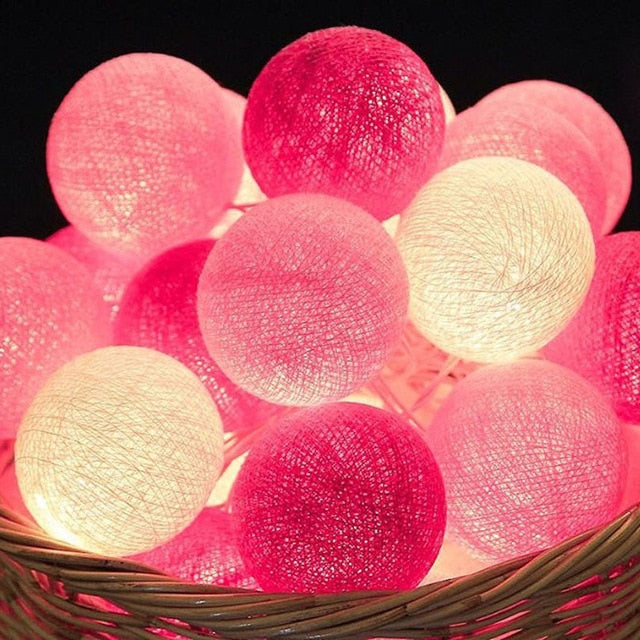 Nahaufnahme bunter LED Baumwoll Lichterkette, sanft leuchtende Bälle für gemütliches Ambiente.