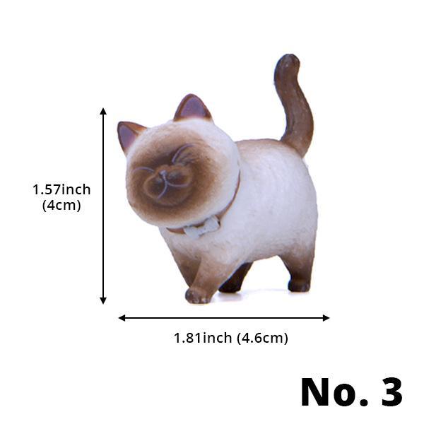 Miniatur Katzenfigur mit drehbarem Kopf auf einem Bücherregal, perfekte Dekoration.