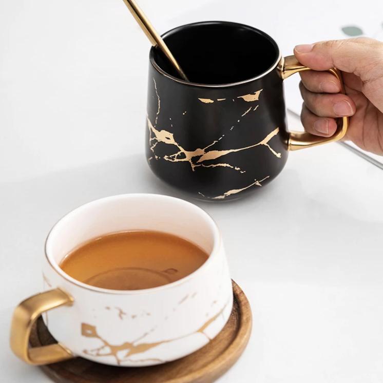 Einzigartige Kintsugi Keramik Tasse, nordisch inspiriert, schwarz-weißes Design mit edlem goldenem Muster.