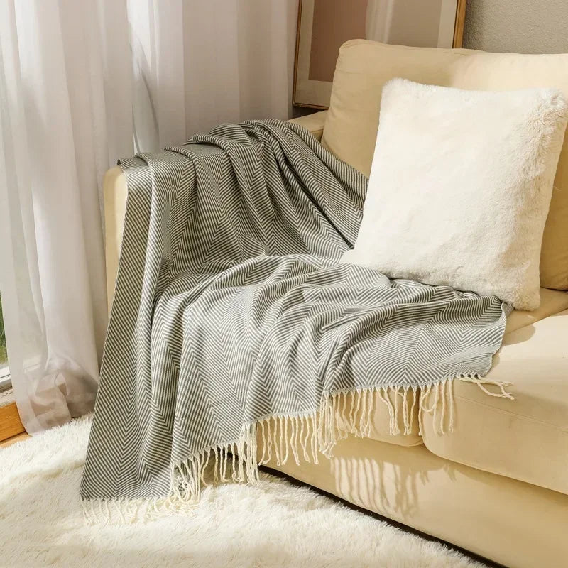 Moderne nordische Wurfdecke aus Baumwolle mit Streifenmuster auf dem Sofa. Für stilvolles Wohnen.