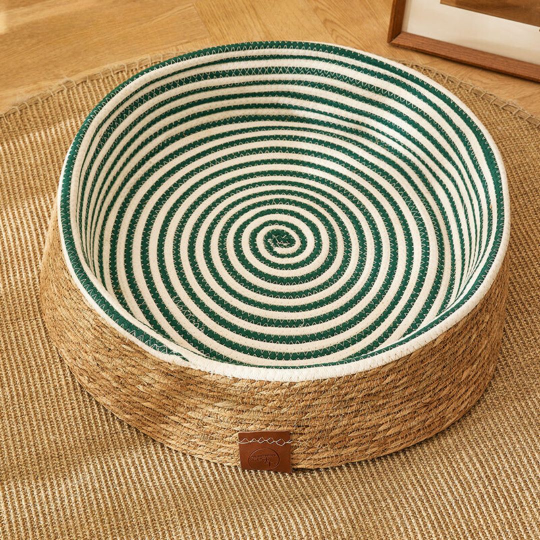 Naturmaterial Rattan: Braun-dunkelgrünes Katzen-Kratzbett, handgeflochten, stilvolles Wohnaccessoire.