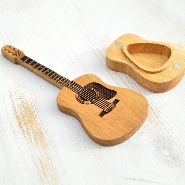 Offene Holzbox gefüllt mit Gitarrenplektren, personalisiertes und praktisches Musikzubehör für Musiker.