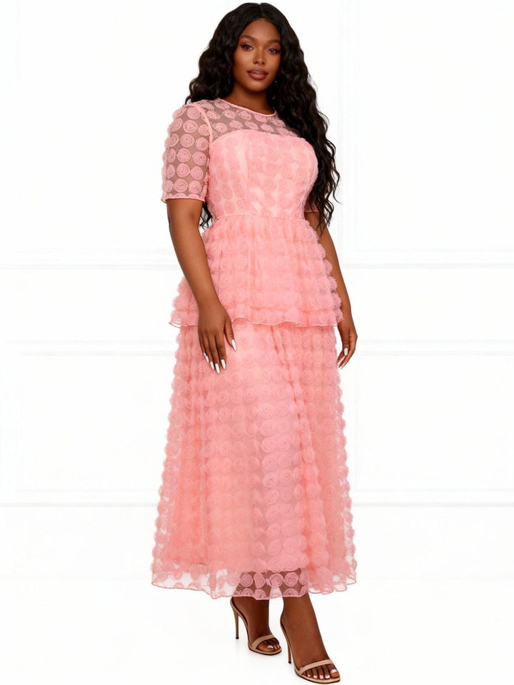 Frauenmodel trägt langes, rosa florales Maxikleid mit Volants. Schickes Party- und Sommerkleid für Damen.