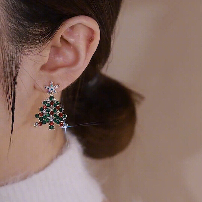 Detailaufnahme: Damen Weihnachtsbaum Ohrringe mit funkelnden Zirkonia, glänzender Weihnachtsschmuck.