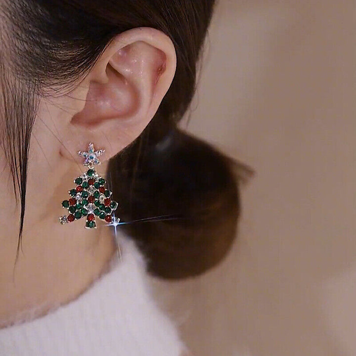 Detailaufnahme: Damen Weihnachtsbaum Ohrringe mit funkelnden Zirkonia, glänzender Weihnachtsschmuck.