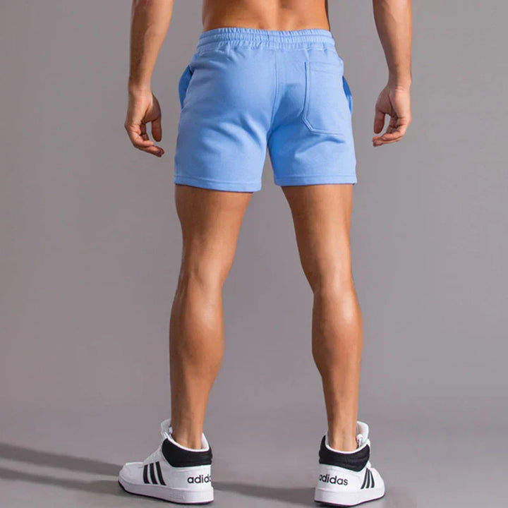 Mann entspannt am Strand in lässigen, bequemen Slim-Fit Herrenshorts.