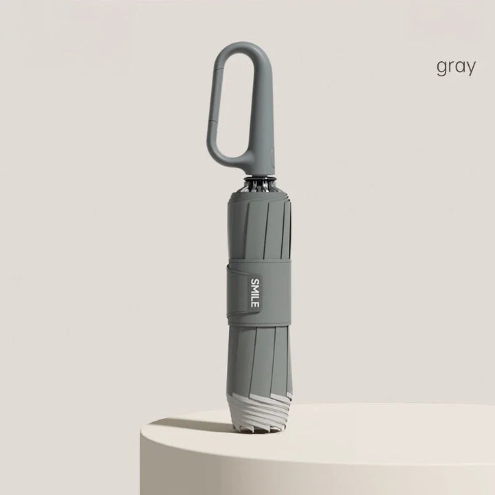 Grauer kompakter Automatik-Regenschirm, wasserdicht & windresistent, perfekt für unterwegs.