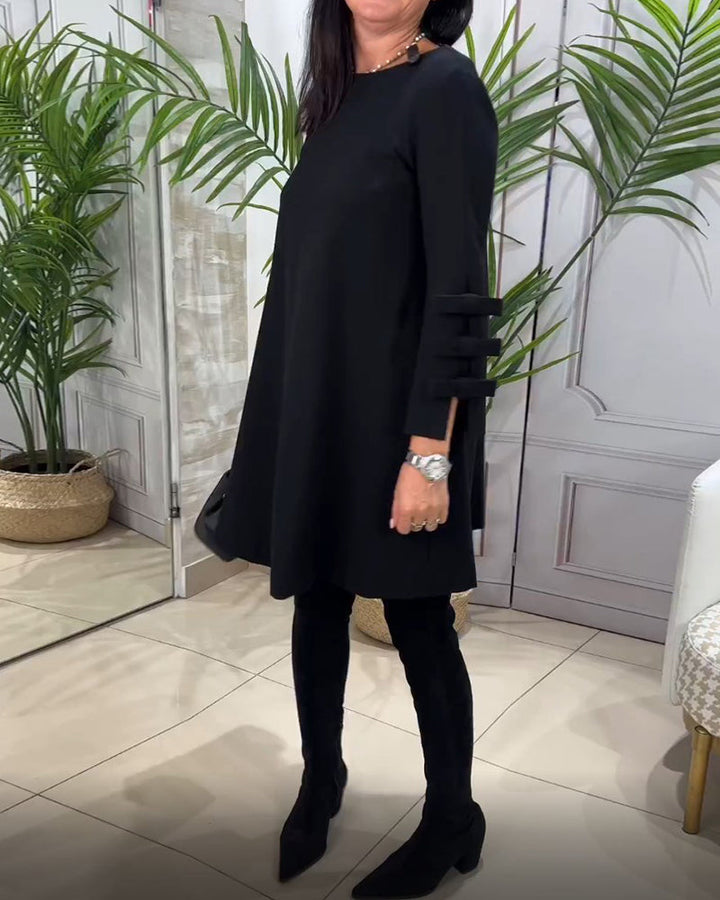Bequemes schwarzes Damenkleid "Nora" mit langen Ärmeln & Fransenakzent. Perfekt für Damenmode im Herbst/Winter.