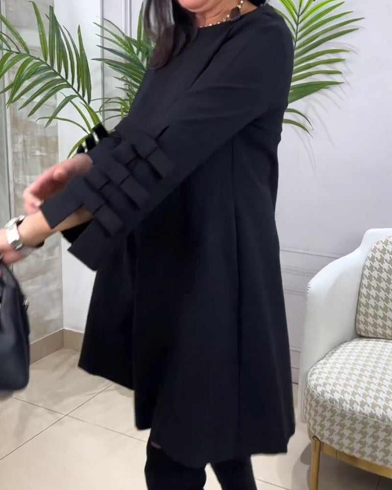 Frau trägt vielseitiges schwarzes Damenkleid "Nora" mit langen Ärmeln. Knielanges Rundhals-Outfit für jede Saison.