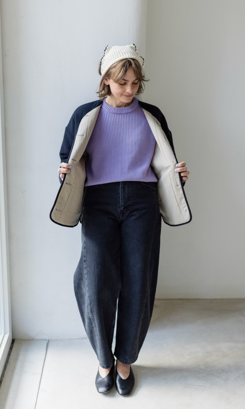Nahaufnahme der schwarzen Steppjacke mit gestepptem Muster, die den lässigen Stil betont.