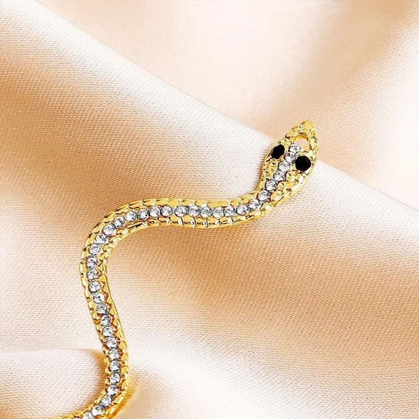 Detailaufnahme: Medusa Schlangenohrring aus Metalllegierung mit Strass. Moderner Damen Ohrschmuck.