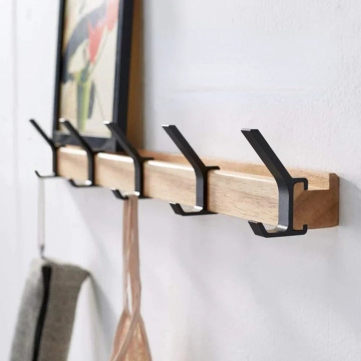 Skandinavische Wandgarderobe aus Holz & Metall mit beweglichen Haken für moderne Flureinrichtung.