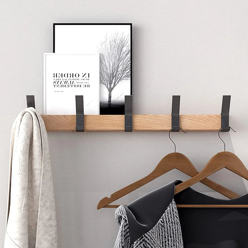 Detailaufnahme der beweglichen Metall-Haken an der skandinavischen Holz-Wandgarderobe, platzsparendes Design.