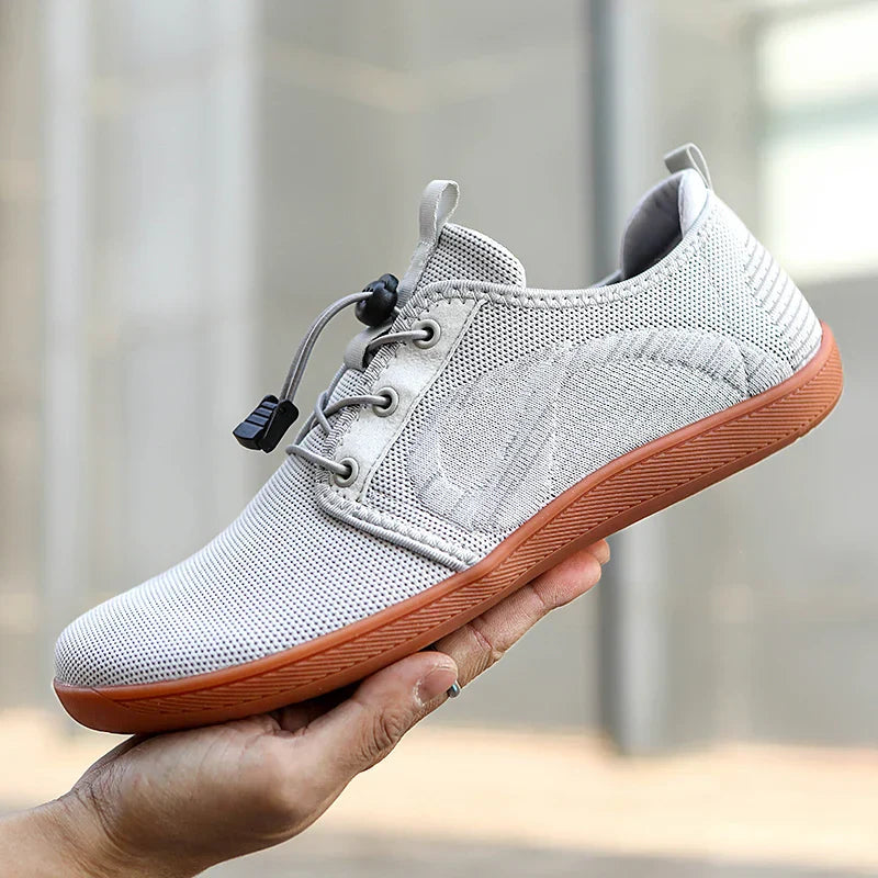 Sportliche Herren-Sneaker in Grau/Schwarz mit roten Akzenten. Bequemer Freizeitschuh für Alltag und Stadt, moderne Herrenmode.