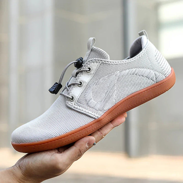 Sportliche Herren-Sneaker in Grau/Schwarz mit roten Akzenten. Bequemer Freizeitschuh für Alltag und Stadt, moderne Herrenmode.