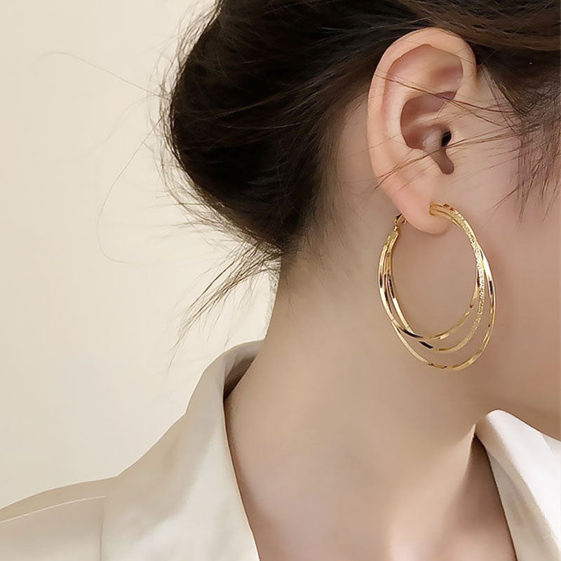 Silberfarbene Damen Dreifach Hoop Ohrringe mit glitzernden Funkelsteinen. Ein modisches Accessoire für jeden Look.