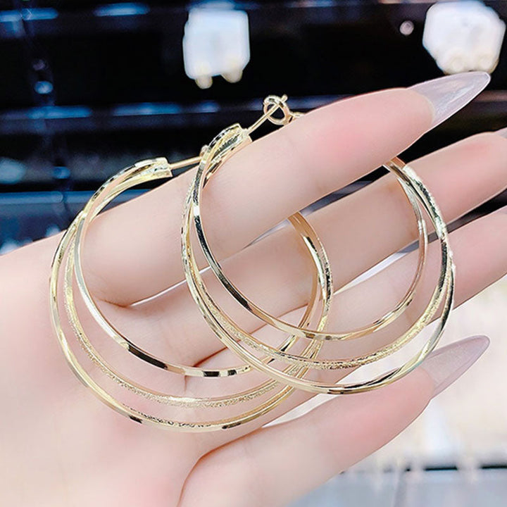 Eleganter Damen Dreifach Hoop Ohrring mit Funkelsteinen. Ein vielseitiges Accessoire, das jedes Outfit aufwertet.
