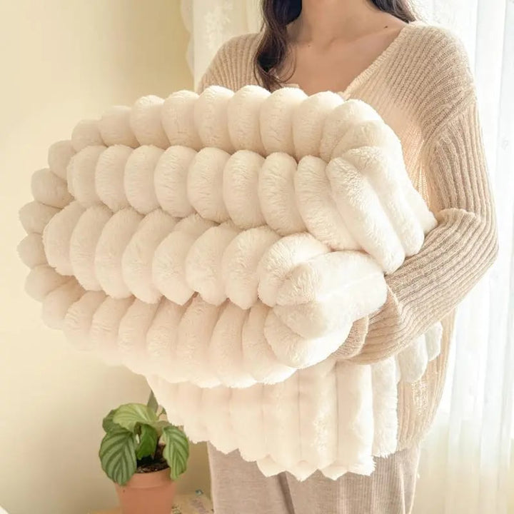 Luxuriöse Kuscheldecke aus weichem Plüsch in Beige; warme Fleecedecke für entspannte Stunden.