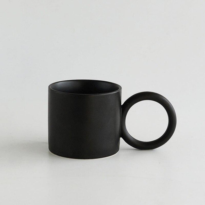 Detailaufnahme der Keramiktasse mit Punkt-Design und ergonomisch geformtem Komfortgriff.