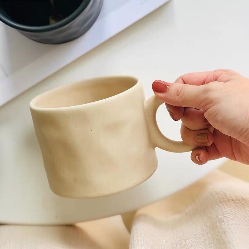 Leere, stilvolle Keramiktasse mit Punkt-Design und Komfortgriff, bereit zum Befüllen.