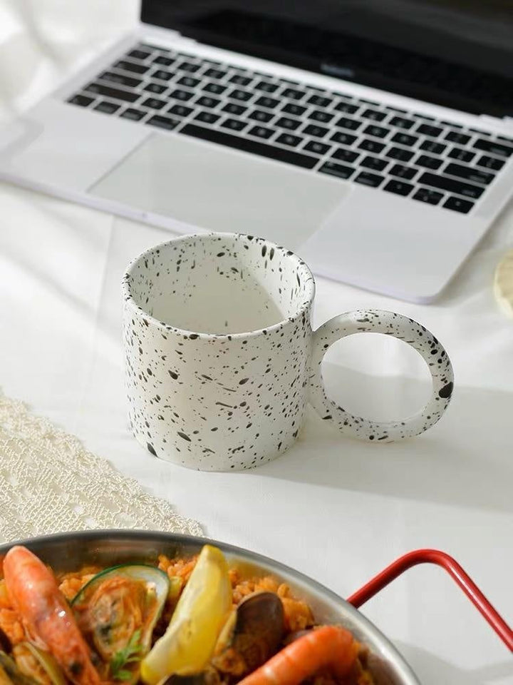 Keramik-Kaffeebecher mit stilvollem Punkt-Design und angenehmem Haltegriff für täglichen Genuss.