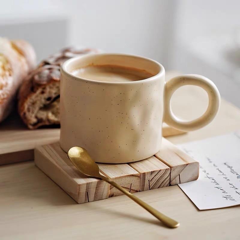 Handlicher Keramik-Kaffeebecher im Punkt-Design mit großem Komfortgriff für entspannte Momente.