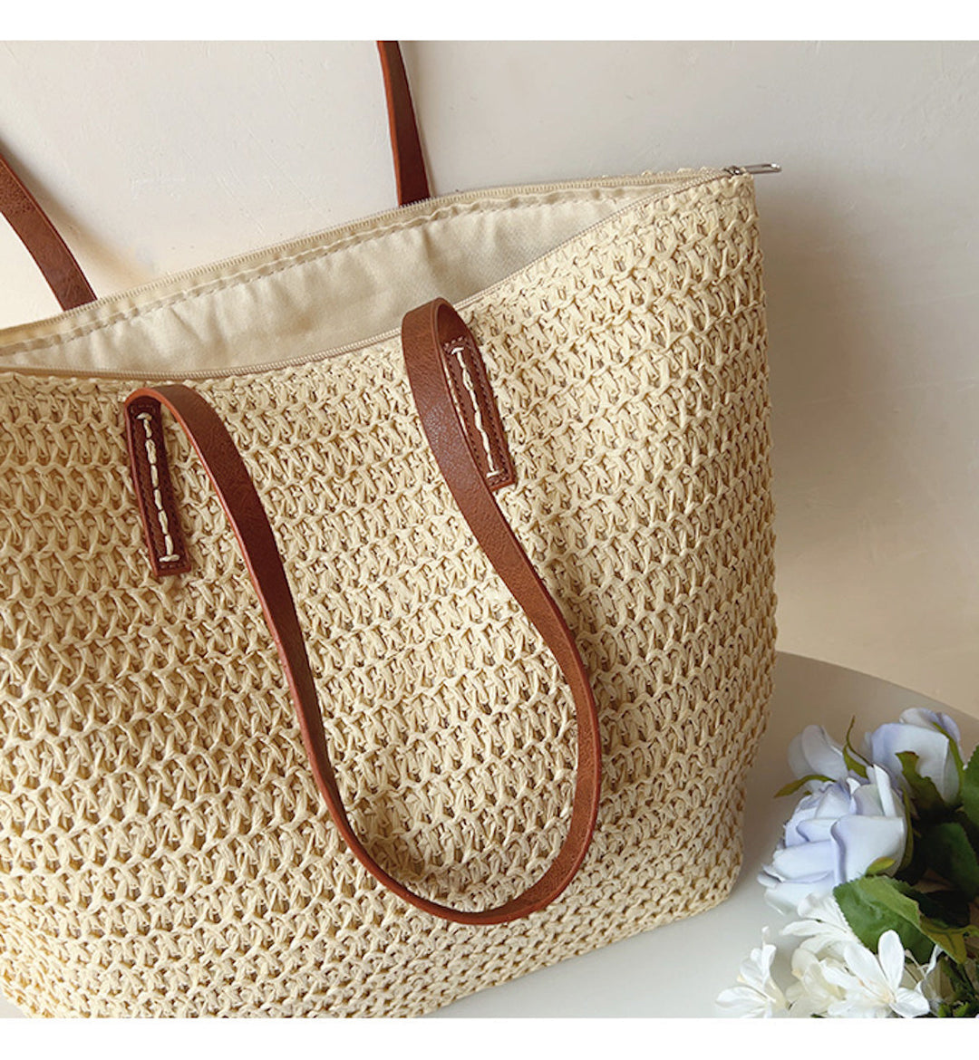 Schicke Korbtasche mit robusten Tragegriffen, das ideale Accessoire für den Sommer und entspannte Tage.