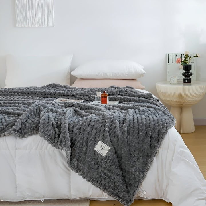 Nahaufnahme der flauschigen Mikrofaser-Kuscheldecke, die Weichheit und Wärme verspricht. Perfekt für Zuhause.