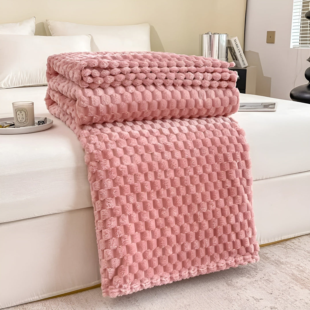 Gerollte, platzsparende Kuscheldecke aus Mikrofaser. Praktisch und superweich für Wohnzimmer und Schlafzimmer.