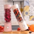 Person bereitet frischen Beeren-Smoothie im handlichen USB-Mixer zu; perfekt für schnelle Vitamine.