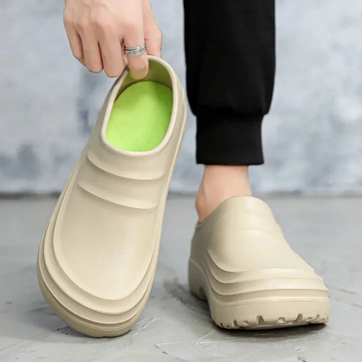 Koch trägt AquaStep Küchenschuhe, wasserdicht und rutschfest, für sicheres Arbeiten am Herd.