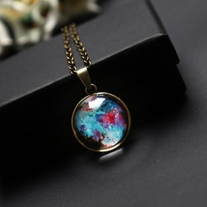 Unisex Kosmos Glaskugel Halskette vor weißem Hintergrund. Faszinierendes Universum & Galaxie Motiv. Exklusiver Schmuck.