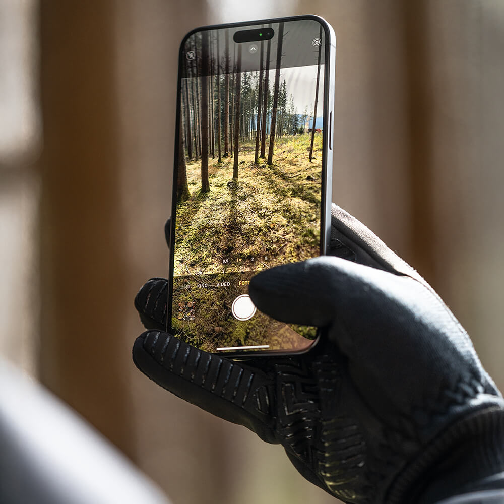 Finger bedient Smartphone mit ThermoFit Touchscreen-Handschuhen. Ideal für Outdoor & kalte Tage.