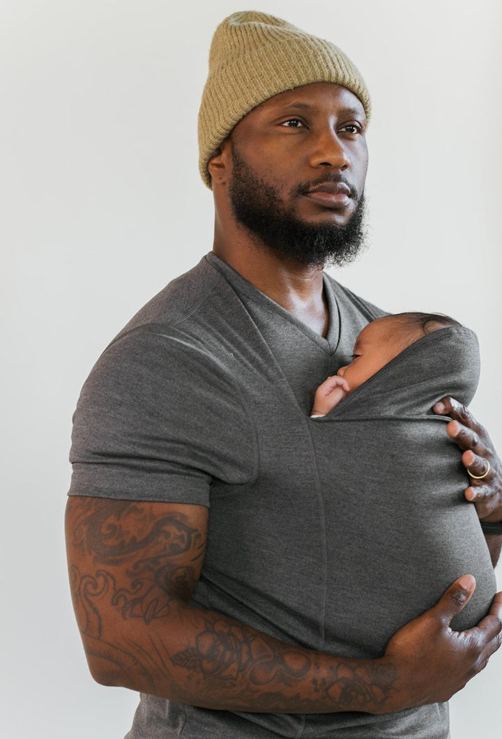 Papa unterwegs mit Baby im stylischen Tragetuch T-Shirt. Moderne Babytrage für aktive Eltern.