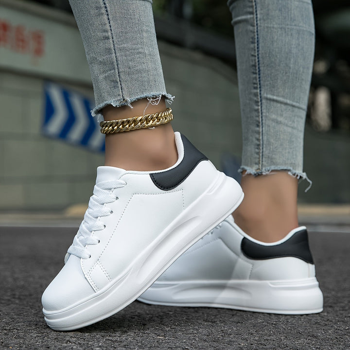 Schlichte weiße Damensneakers, zeitloses Design für lässige Frühjahrs- und Sommer-Looks.