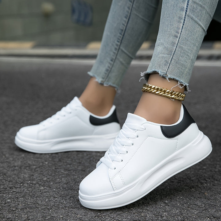 Vorderansicht stilvoller weißer Damen-Sneaker, perfekt für lässige Frühjahrs- und Sommer-Outfits.