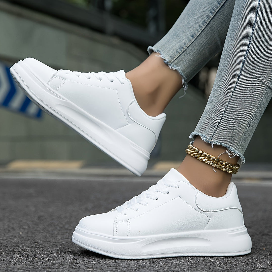 Weiße Damensneakers am Fuß, zeigen Komfort und Stil für tägliche Aktivitäten im Frühling.